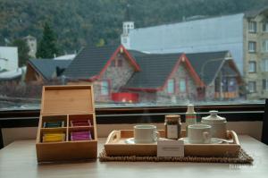 a table with a tray with cups and tea sets on it at Departamentos - Belgrano 810 in San Martín de los Andes