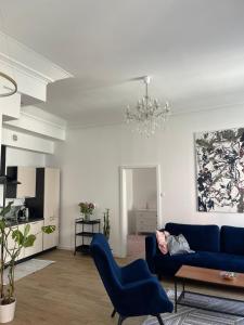 Una sala de estar con un sofá azul y una lámpara de araña. en Narutowicza 18, en Lublin