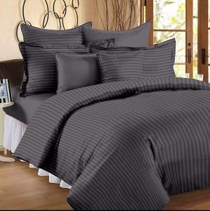 a bed with a black and grey striped comforter at Hotel Aeroporto Near By Domestic Airport in New Delhi
