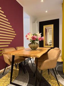 ein Esstisch mit einer Vase mit Blumen darauf in der Unterkunft Classy Suite Museumsquartier in Wien