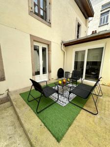 a patio with chairs and a table on grass at Epinal Hyper Centre, Place des Vosges T2 avec terrasse et salon de jardin. in Épinal