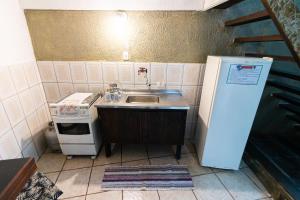 uma pequena cozinha com um lavatório e um frigorífico em Pousada Maré Alta - MARESIAS em Maresias
