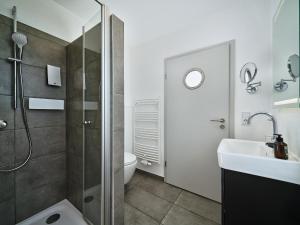 a bathroom with a shower and a sink at Hotel Siebzehn80 in Carolinensiel