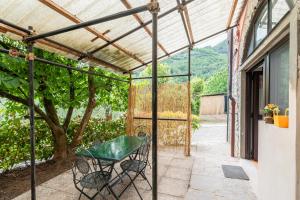 eine Terrasse mit einem grünen Tisch und einem Baum in der Unterkunft Casa delle Rose in Borgo a Mozzano