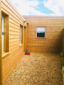 un edificio de madera con una ventana lateral en Delphi Cottage en Ashbourne