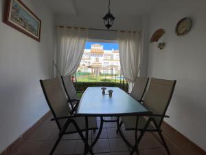 a table and chairs in a room with a window at Apartamento a pie de playa in Rota