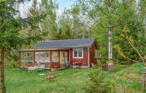 a red cabin in the middle of the forest at Stunning Home In Kallinge With Lake View in Kallinge