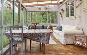 un porche cubierto con mesa y sofá en Stunning Home In Kallinge With Lake View, en Kallinge
