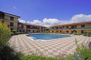 una grande piscina in un cortile con edifici di Appartamento Chiaretto - Gardagate a Moniga