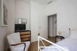 a bedroom with a bed and a chair and a television at -Art Gallery- Luxury Boutique in center of Como in Como