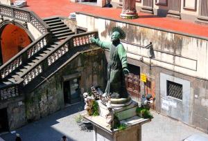 a statue of a man standing next to a building at B&B Domus Gemi in Naples