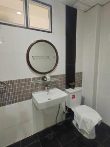 un bagno con lavandino, specchio e WC di The Rich Room ห้องพักโคราช a Ban Pra Dok