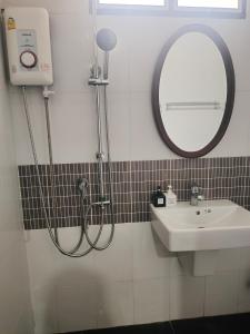 un bagno con doccia, lavandino e specchio di The Rich Room ห้องพักโคราช a Ban Pra Dok