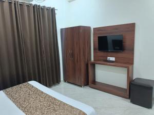 a hotel room with a tv and a bed and curtains at hotel saanjh haveli in Orchha