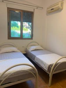 two beds in a room with a window at Velipoja Sea House in Velipojë