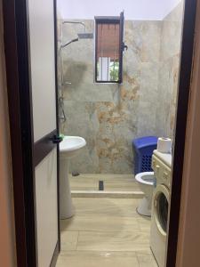 a bathroom with a toilet and a sink and a washing machine at Velipoja Sea House in Velipojë +14 photos
