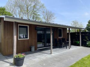 a building with glass doors and a patio at Wad Mooi in Tzummarum
