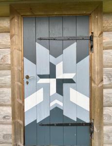 a door with a white cross painted on it at Tagavälja talu Cottage and Sauna on a farm B&B, rural experience in Atsalama +19 photos