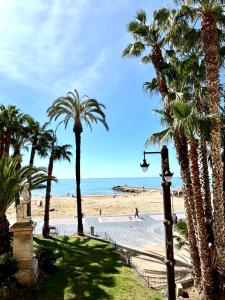 vistas a una playa con palmeras y luz de la calle en Hotel Celimar, en Sitges