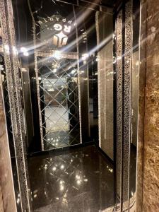 reflejo de una habitación con espejo y algunas luces en رويال جروب اربد Royal Group Hotel, en Irbid