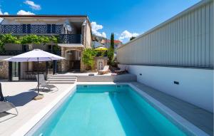 a swimming pool in the backyard of a house at Cozy Home In Starigrad Paklenica in Starigrad-Paklenica