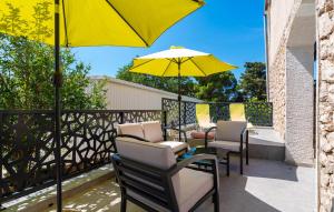 a group of chairs and an umbrella on a balcony at Cozy Home In Starigrad Paklenica in Starigrad-Paklenica +33 photos