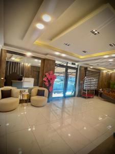 een lobby met 2 stoelen en een vaas met bloemen bij رويال جروب اربد Royal Group Hotel in Irbid