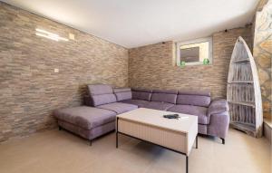 a living room with a purple couch and a table at Cozy Home In Starigrad Paklenica in Starigrad-Paklenica