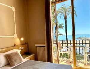 a bedroom with a bed and a view of the ocean at Hotel Celimar in Sitges