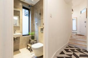 a bathroom with a toilet and a sink at Spacious and Charming Brixton Home in London