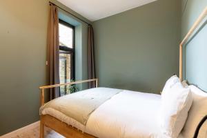 倫敦的住宿－Spacious and Charming Brixton Home，一间卧室设有一张床和一个窗口