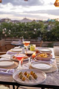 Almaha Marrakech Restaurant & SPA في مراكش: طاولة مع أطباق من الطعام وكؤوس النبيذ