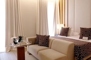 a hotel room with a bed and a couch at Hospes Amérigo, Alicante, a Member of Design Hotels in Alicante