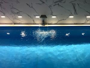 une fontaine dans une piscine d'eau bleue dans l'établissement Villa Sarajevo, à Vareš