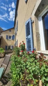 un edificio con una ventana con un ramo de flores en La Grange Des Roches Roses, en Anchenoncourt-et-Chazel