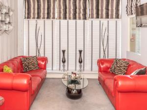 a living room with two red couches and a table at The Kenley Hotel in Blackpool