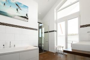 a bathroom with a white tub and a sink at Villa Seestern in Trent +19 photos