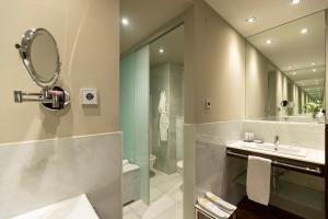 a bathroom with a shower and a sink and a mirror at Hospes Amérigo, Alicante, a Member of Design Hotels in Alicante
