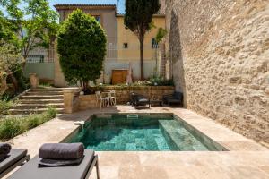 a swimming pool in a courtyard with a building at La Grande Maison Chambres d'Hôtes in Peyriac-de-Mer