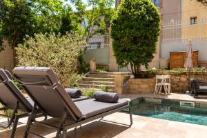 a pair of chairs sitting next to a swimming pool at La Grande Maison Chambres d'Hôtes in Peyriac-de-Mer