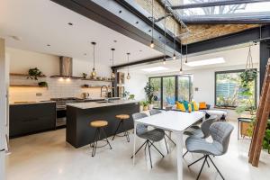 an open kitchen and dining room with a table and chairs at Spacious and Charming Brixton Home in London