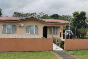 a house with a car parked in front of it at Arenal TitaHouse in Agua Azul