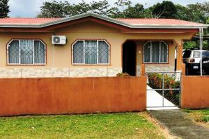 a house with a fence in front of it at Arenal TitaHouse in Agua Azul +7 photos
