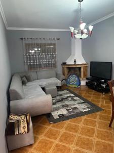 a living room with a couch and a television at Villa in velipoje, a place to remember! in Velipojë