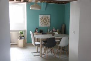 una sala da pranzo con pareti blu e tavolo e sedie di Agréable maison de ville de 120m² à Villejust a Villejust