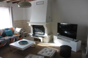 a living room with a fireplace and a tv at Agréable maison de ville de 120m² à Villejust in Villejust