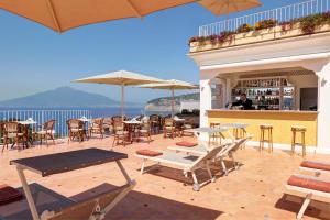 a patio with tables and chairs and a bar at Grand Hotel de la Ville in Sorrento