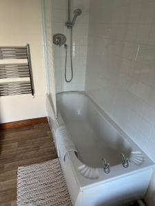 科爾福德的住宿－4 Foundry House，带淋浴的浴室配有白色浴缸。