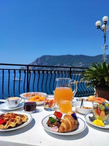 a table with plates of breakfast foods and orange juice at Hotel Porto Roca in Monterosso al Mare