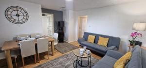 ein Wohnzimmer mit einem blauen Sofa und einem Tisch in der Unterkunft Modern 2 Bedroom Apartment in London